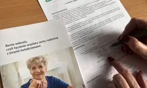 Dłoń wypełnia formularz ZUS, obok uśmiechnięta starsza kobieta.