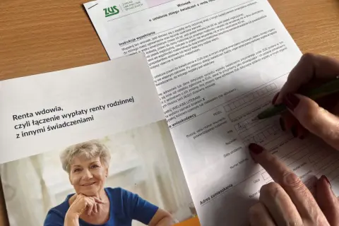 Dłoń wypełnia formularz ZUS, obok uśmiechnięta starsza kobieta.